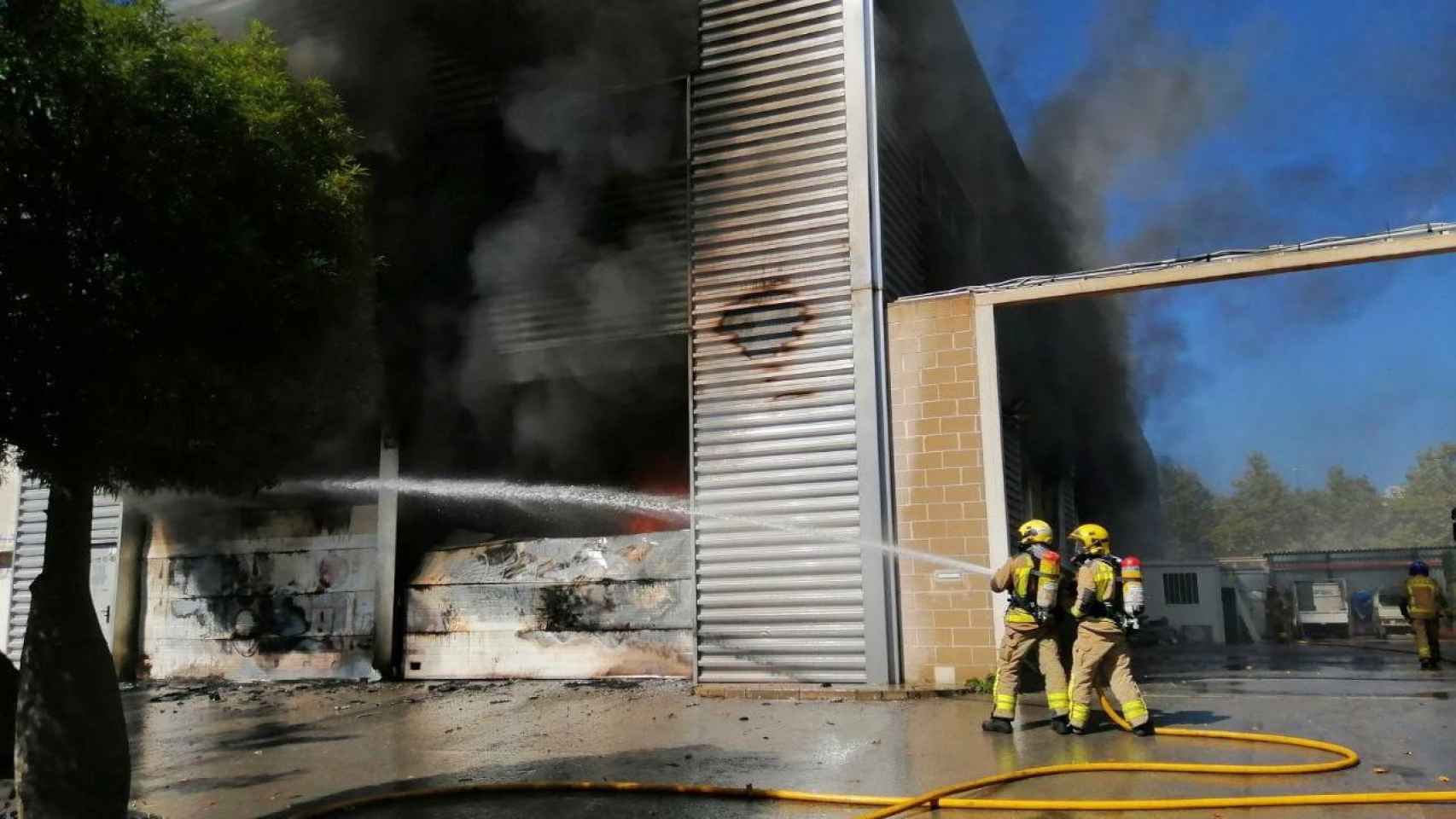 Los bomberos intentan apagar el fuego en una nave industrial de Castelldefels / BOMBERS