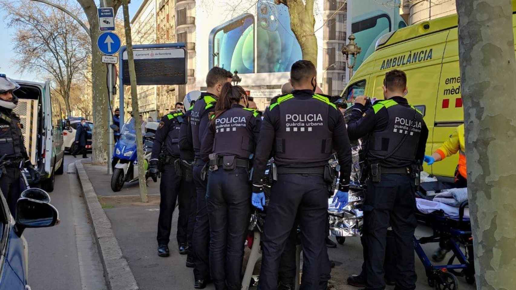 Agentes de la Guardia Urbana, ayudando a una mujer que se puso de parto en la Gran Vía de Barcelona / @GUBBarcelona (TWITTER)