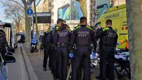 Agentes de la Guardia Urbana, ayudando a una mujer que se puso de parto en la Gran Vía de Barcelona / @GUBBarcelona (TWITTER)