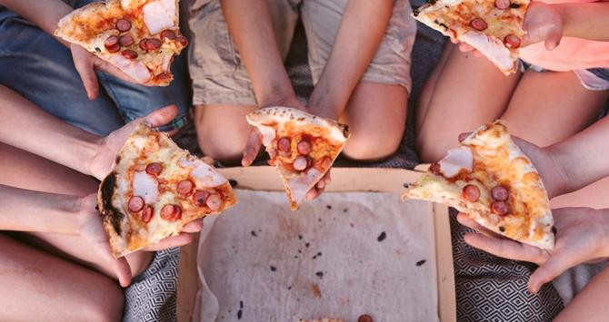 Varios niños comiendo pizza / FREEPIK