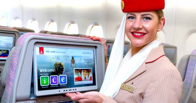 Una azafata de Emirates muestra la pantalla en el asiento del avión / EMIRATES