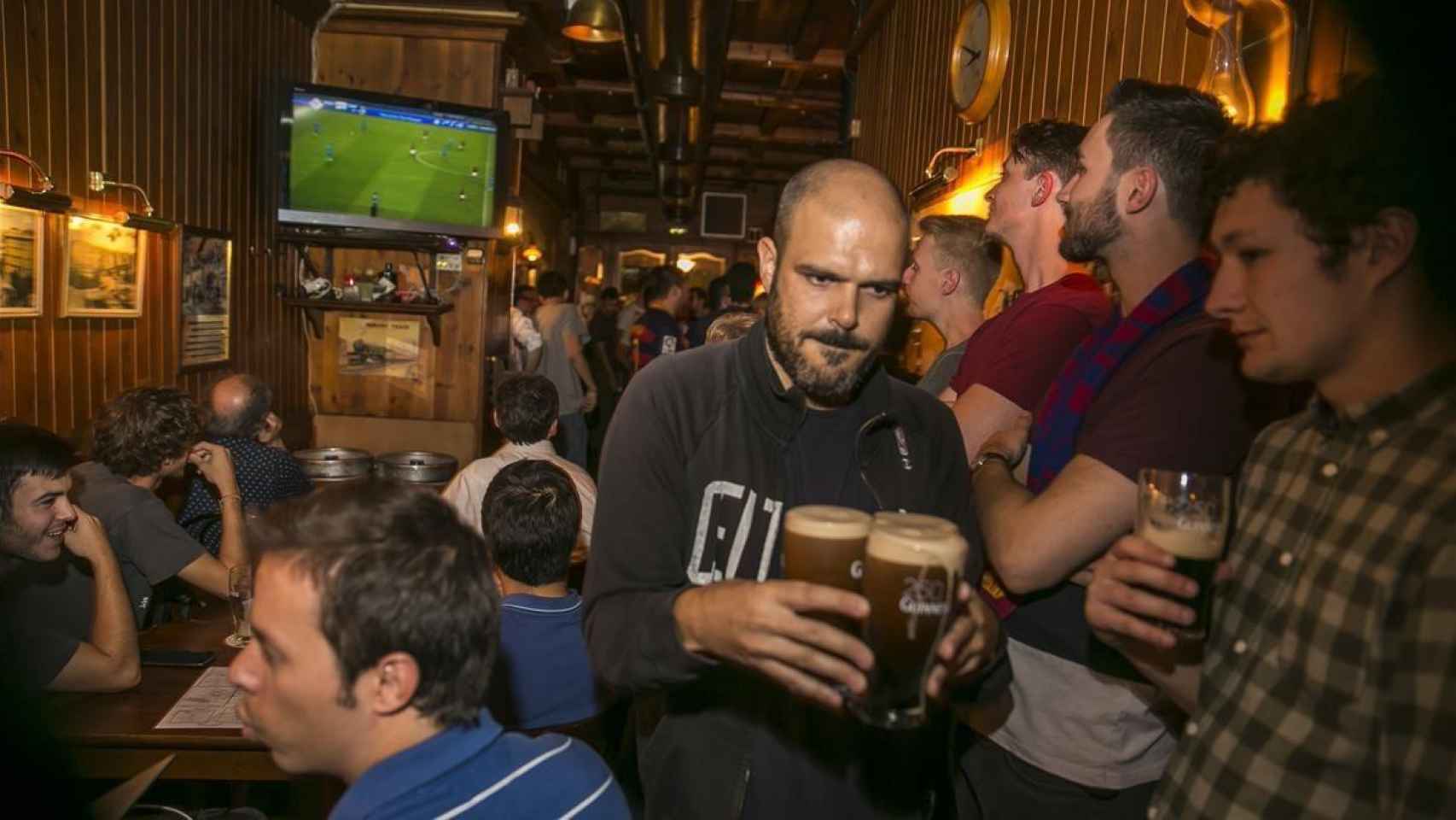 Aficionados al fútbol presencia un partido en un bar