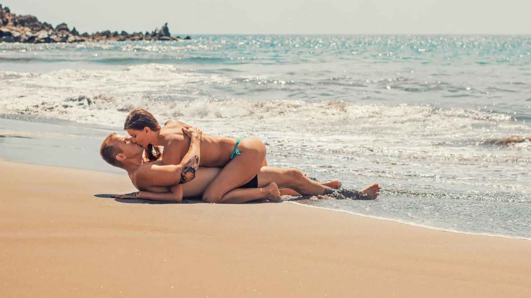 Imagen de una pareja besándose en la playa
