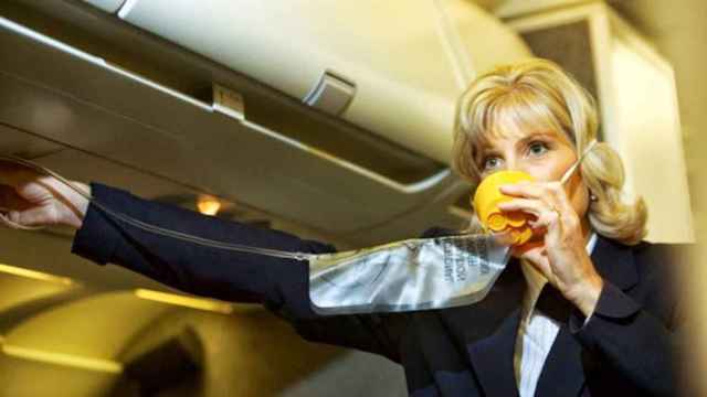 Una foto de archivo de una azafata con una mascarilla en un avión