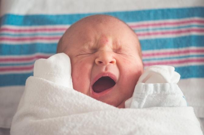 Un bebé recién nacido bostezando / Etim Bish en UNSPLASH
