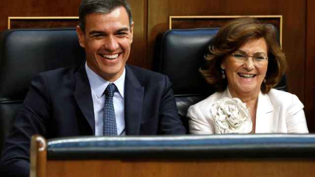 Pedro Sánchez y Carmen Calvo ríen durante la votación de la investidura del primero / EFE