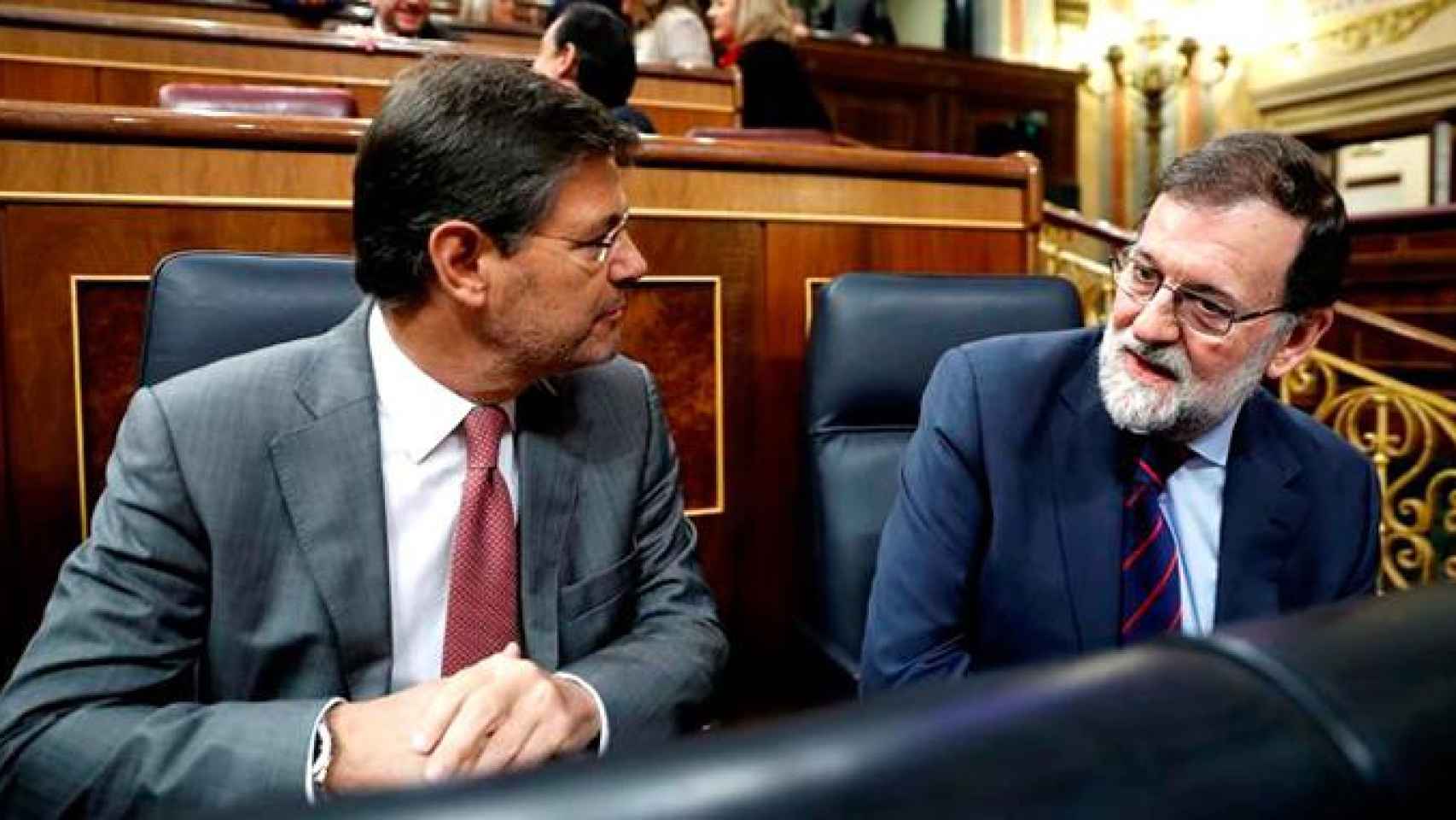 El presidente del Gobierno, Mariano Rajoy (d), conversa con el ministro de Justicia, Rafael Catalá (i), en el Congreso este miércoles / EFE