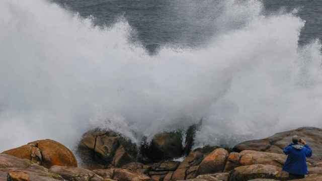 Un turista fotografía las olas esta mañana en Muxía / EFE Lavandeira jr