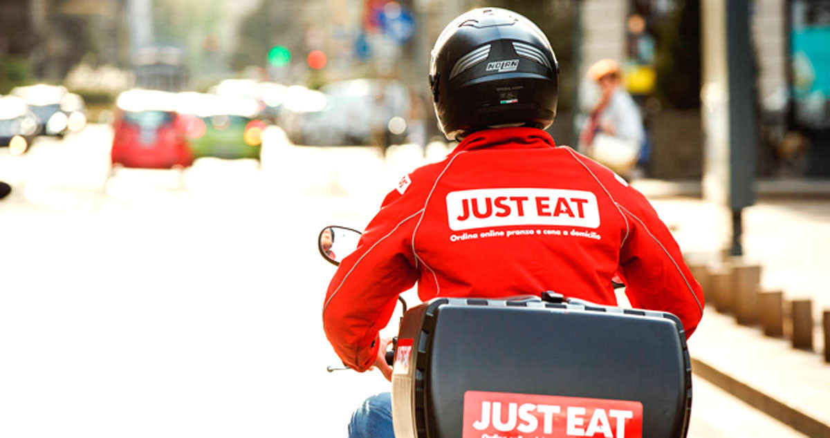 Un trabajador de Just Eat lleva la comida a un cliente en moto