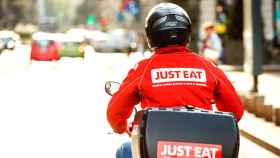 Un trabajador de Just Eat lleva la comida a un cliente en moto