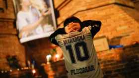 Un aficionado del fútbol con la camiseta de Maradona en el Arco de Triunfo / Reuters