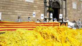 Miles de lazos amarillos volcados por Els Segadors del Maresme ante el Palau de la Generalitat, una acción que vigilan los Mossos / ELS SEGADORS DEL MARESME