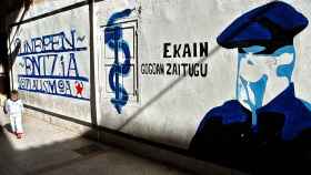 Un niño camina al lado de un mural a favor de ETA / EFE
