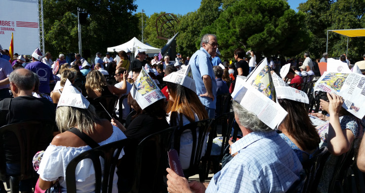 Los asistentes se hicieron gorros de papel para cubrirse del sol, en el Parque de Can Zam, Santa Coloma