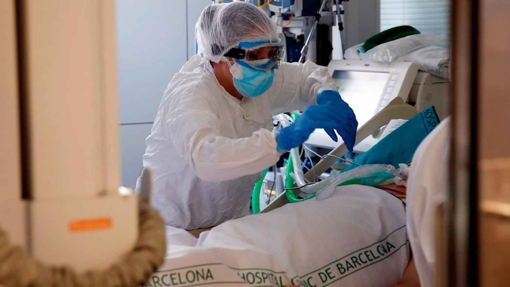 Un sanitario atiende a un paciente con Covid-19 en una de las ucis de Cataluña / EFE