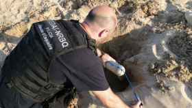 Un Mosso d'Esquadra miembro de los Tedax analiza el explosivo hallado en la playa de la Arrabassada, en Tarragona / EP