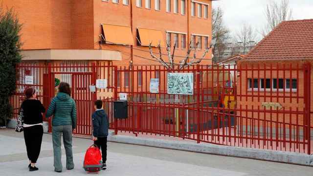 Unos padres acompañan a su hijo al colegio / EFE