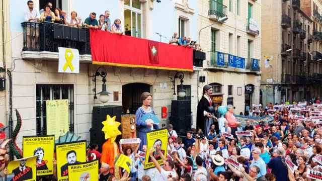 Carteles independentistas y pro presos en el público y la fachada del distrito durante el pregón de las fiestas de Gràcia / CG