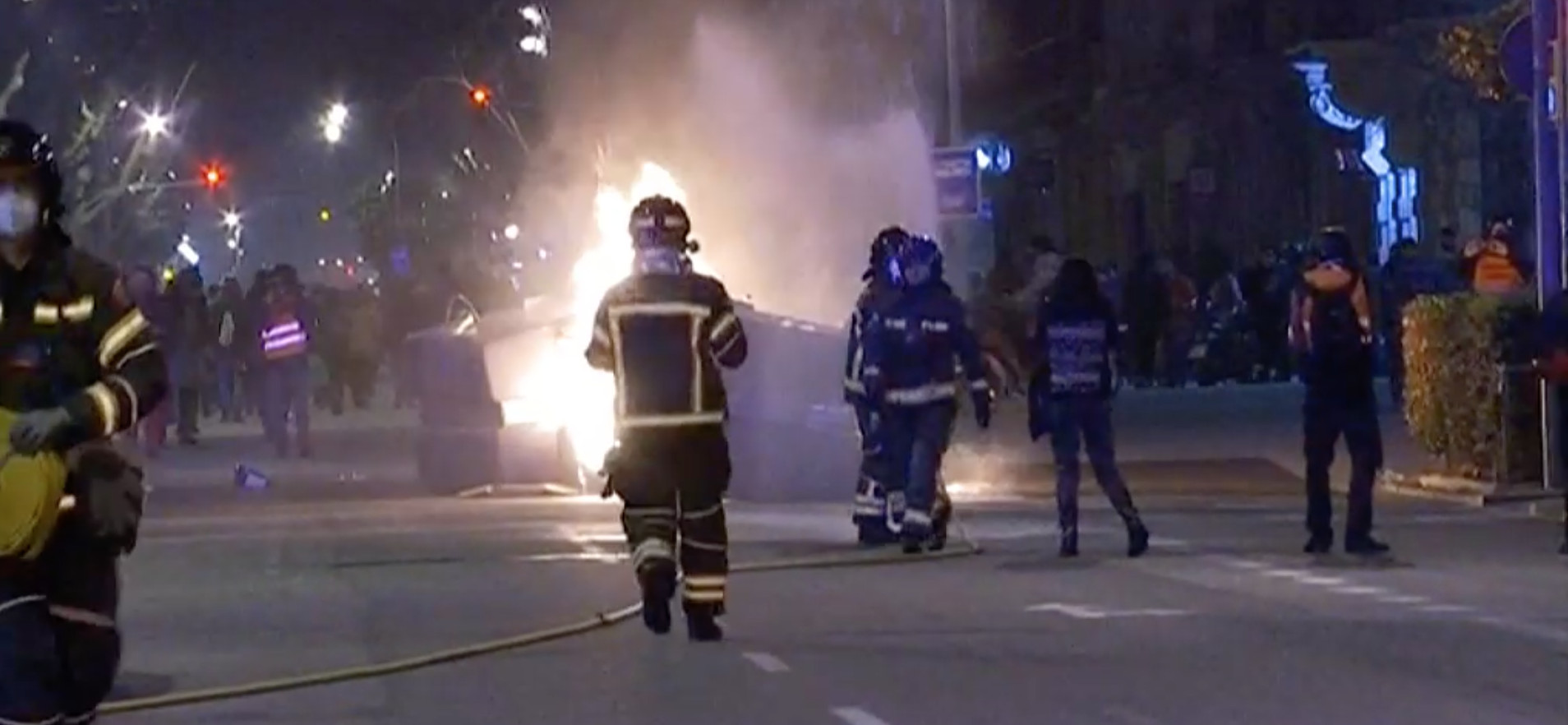Bomberos apagan un fuego en el centro de Barcelona durante la cuarta noche de disturbios por la detención de Pablo Hasél / YOUTUBE