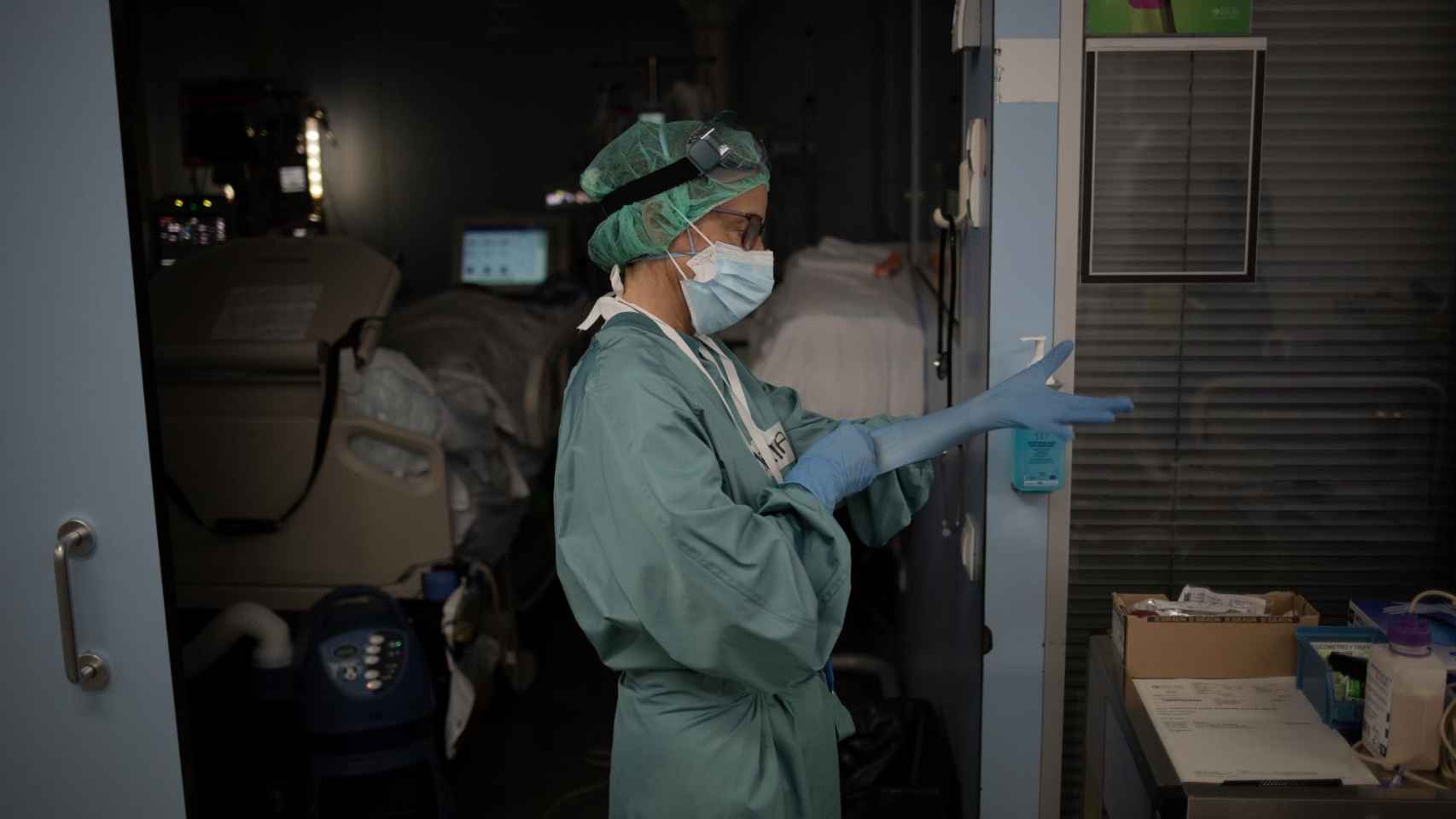 Una sanitaria se pone los guantes en la uci del Hospital de la Santa Creu i Sant Pau, en Cataluña / EP
