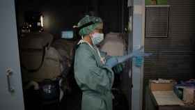 Una sanitaria se pone los guantes en la uci del Hospital de la Santa Creu i Sant Pau, en Cataluña / EP