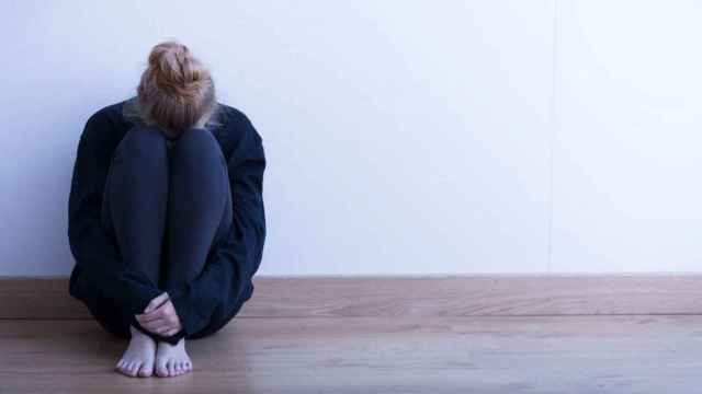 Una joven, sentanda en el suelo, para ilustrar el estigma contra los enfermos mentales / EFE