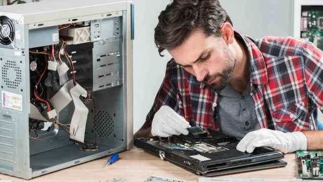 Un técnico emprendedor repara un ordenador portátil / FREEPIK