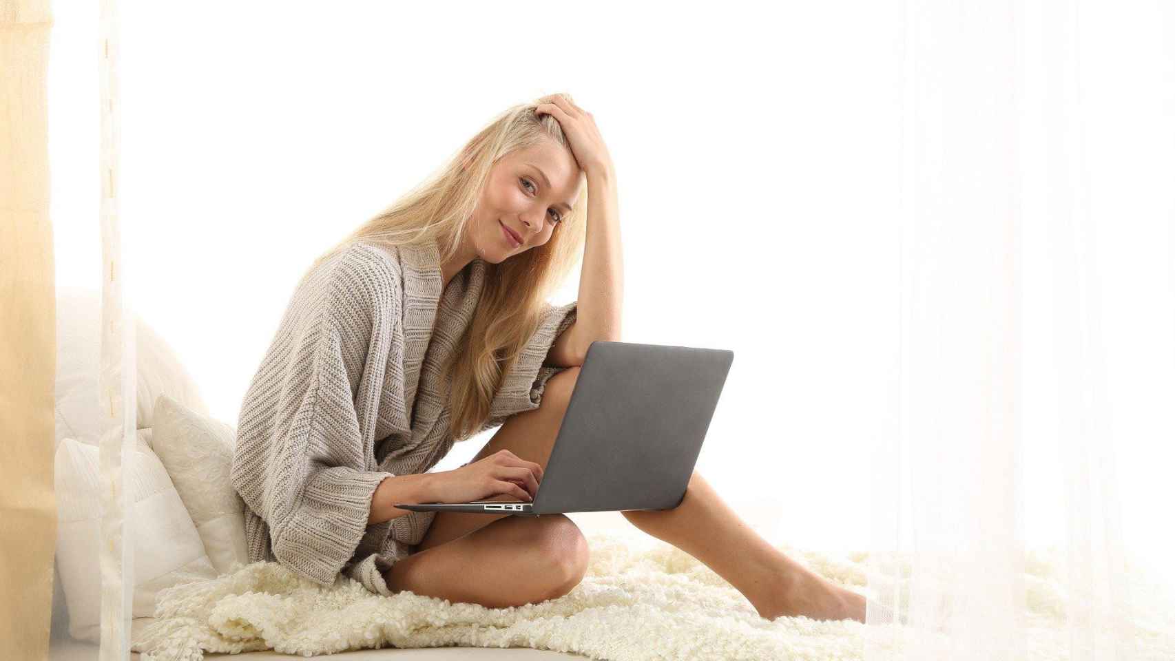 Una mujer de España mira el ordenador encima de su cama / CG