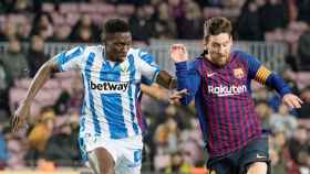 El delantero del Barça Leo Messi (d) se escapa del nigeriano Kenneth Omeruo, del CD Leganés, en un Camp Nou con muchos asientos libres / EFE