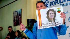 El presidente del PPC y candidato a la presidencia de la Generalitat, Xavier García Albiol, muestra un cartel con la imagen de la ministra de Sanidad, Dolors Montserrat, mientras participa en un almuerzo-mitin en Sant Sadurní / EFE