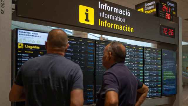 Dos viajeros consultan los vuelos cancelados por la huelga en el aeropuerto de El Prat / EUROPA PRESS