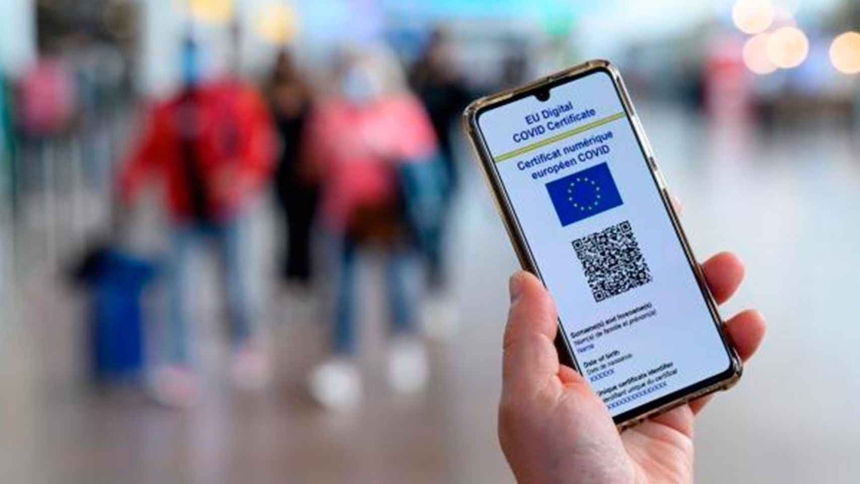 Un pasajero sostiene su teléfono móvil con el Certificado Covid en el aeropuerto / COMISIÓN EUROPEA
