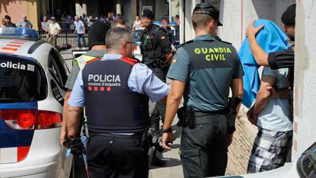 Un agente de los Mossos d'Esquadra, junto a una Guardia Civil, durante los registros tras los atentados de Barcelona y Cambrils / EFE