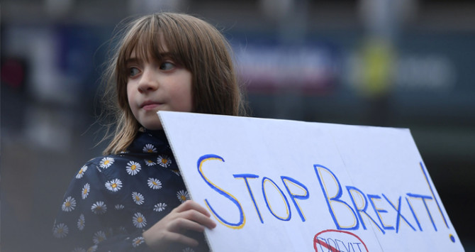 Una niña sostiene un cartel que pide parar el brexit / EE