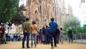 Turistas internacionales de espaldas ante la Sagrada Familia de Barcelona / CG