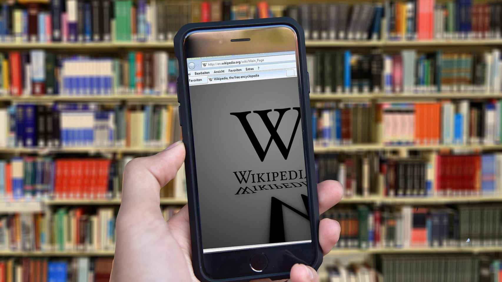 Un alumno consulta la Wikipedia en una biblioteca, desde su móvil / CG