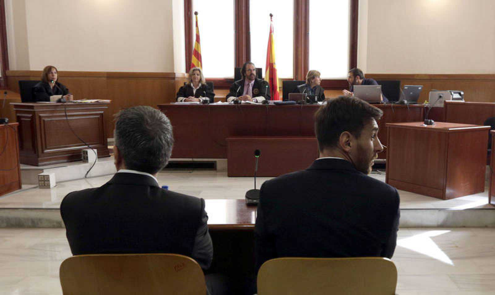 Leo Messi, en la Audiencia Provincial de Barcelona sentado en el banquillo de los acusados junto a su padre, Jorge Messi / EFE