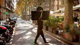 Imagen de un camarero trasladando una terraza en Las Ramblas / CG