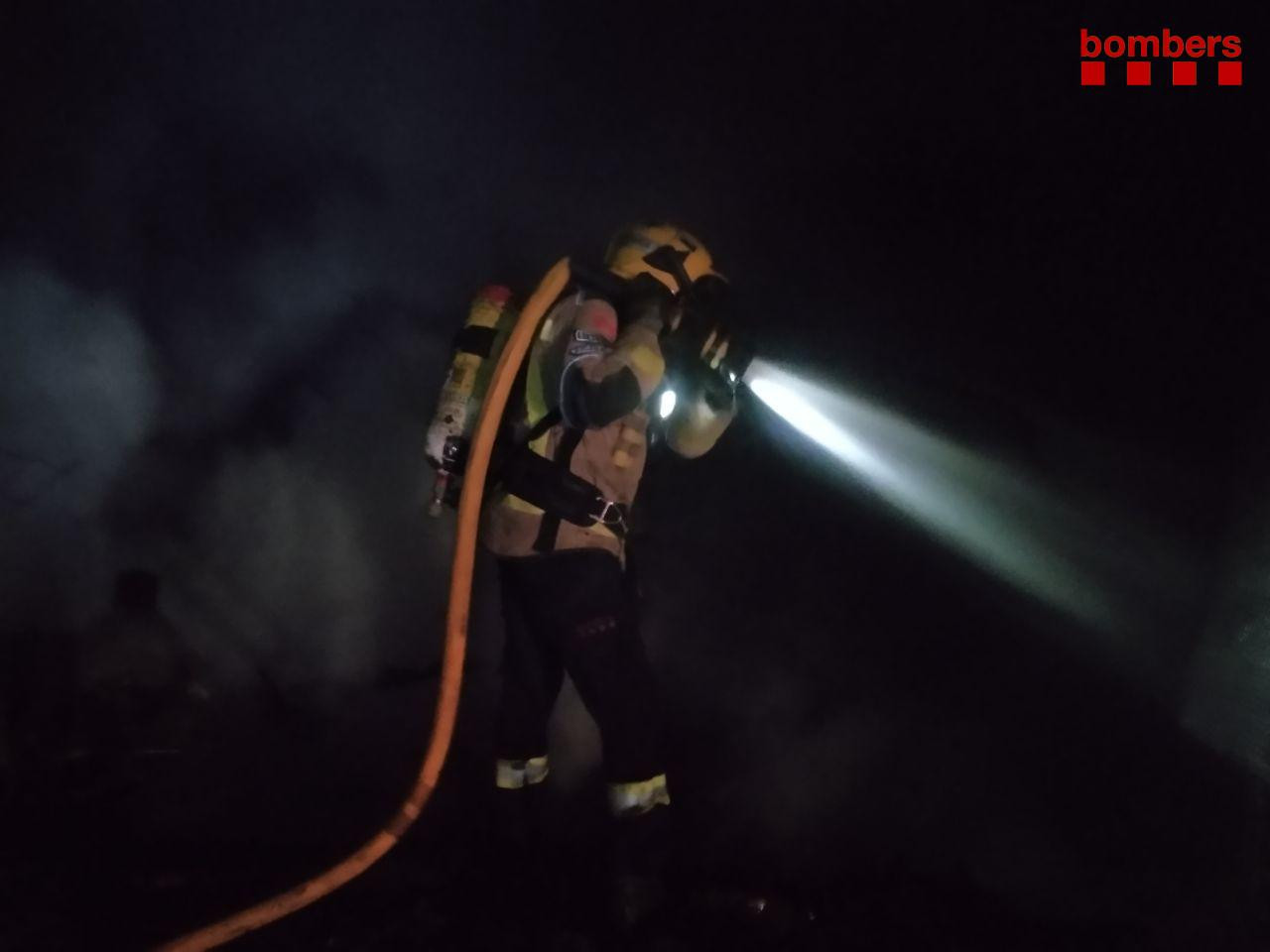 Un bombero durante la extinción del fuego en las barracas de Terrassa / BOMBERS