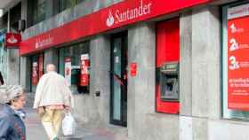 Dos personas mayores pasan ante una sucursal del Santander / CG