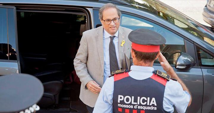 El presidente de la Generalitat, Quim Torra, saludado por un agente de los Mossos d'Esquadra. 'Hay que cuadrar a los de la escuadra', por Ramón De España / EFE