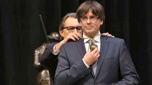 Carles Puigdemont, junto a Artur Mas, durante el acto de toma de posesión del cargo de presidente de la Generalitat.