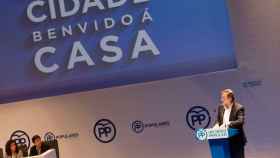 Mariano Rajoy ante una pantalla con el lema Bienvenido a casa en gallego.
