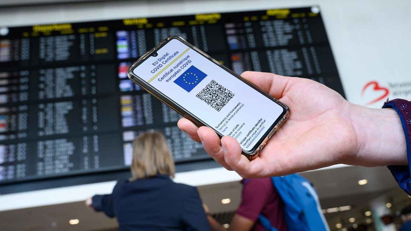 Un pasajero sostiene su teléfono móvil con el Certificado Covid en el aeropuerto antes de viajar / COMISIÓN EUROPEA