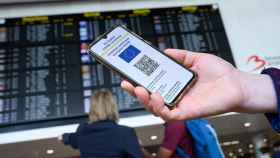 Un pasajero sostiene su teléfono móvil con el Certificado Covid en el aeropuerto antes de viajar / COMISIÓN EUROPEA