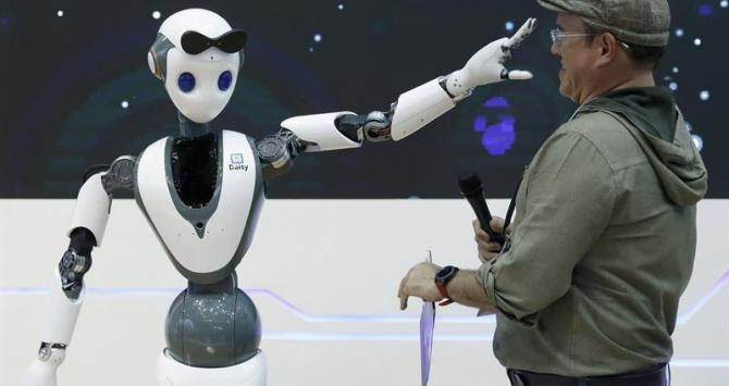 Un robot con tecnología 5G juguetea con uno de las asistentes al Mobile World Congress / EFE