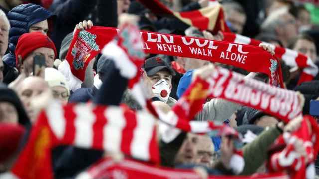 Una aficionado en Anfield tomando medidas contra el coronavirus / EFE