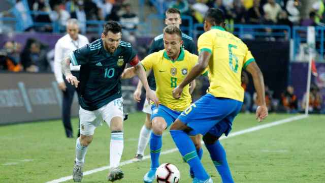 Messi encara a Arthur y Alex Sandro en el Superclásico / EFE