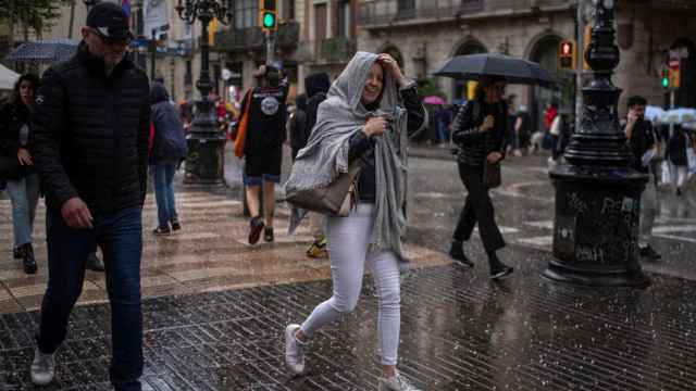Varias personas se cubren de la lluvia / LORENA SOPENA - EUROPA PRESS