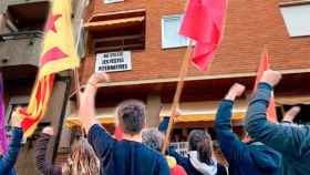 Miembros de Arran ante una finca de vecinos de Gràcia que rechaza las fiestas alternativas / FOTOMONTAJE DE CG